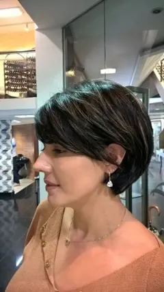 Corte curto em cabelo preto visto de perfil